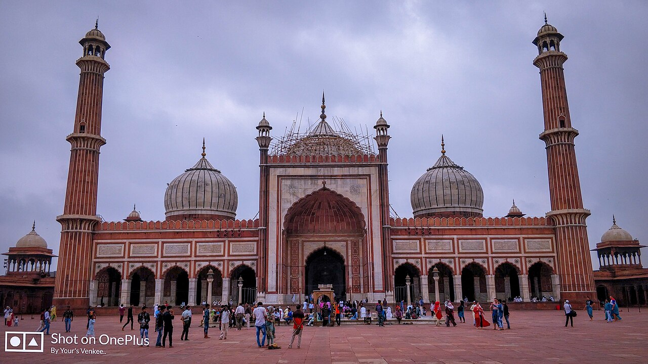 Jama Masjid in Delhi, sandstone domes and minarets across the courtyard, photographed in 2018.
